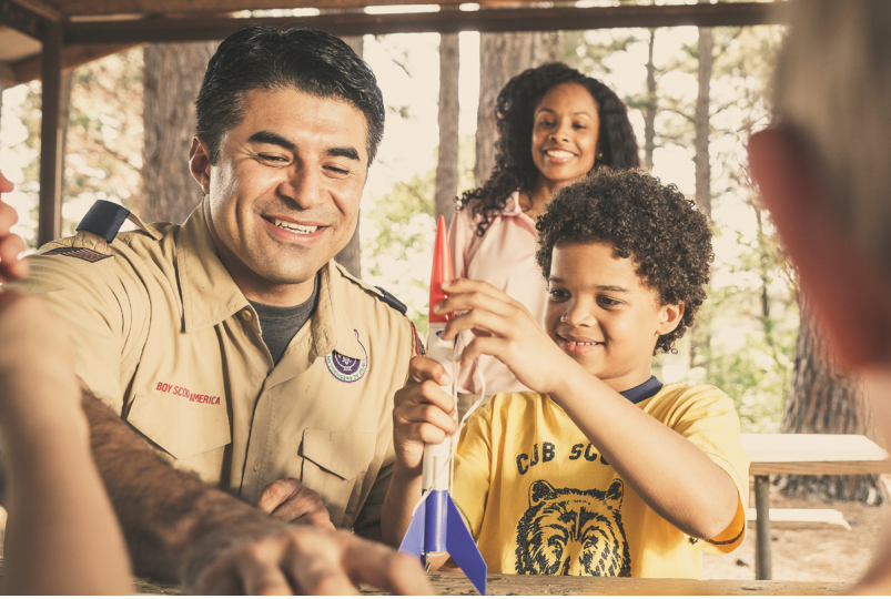 A Scout assembles a rocket with his dad