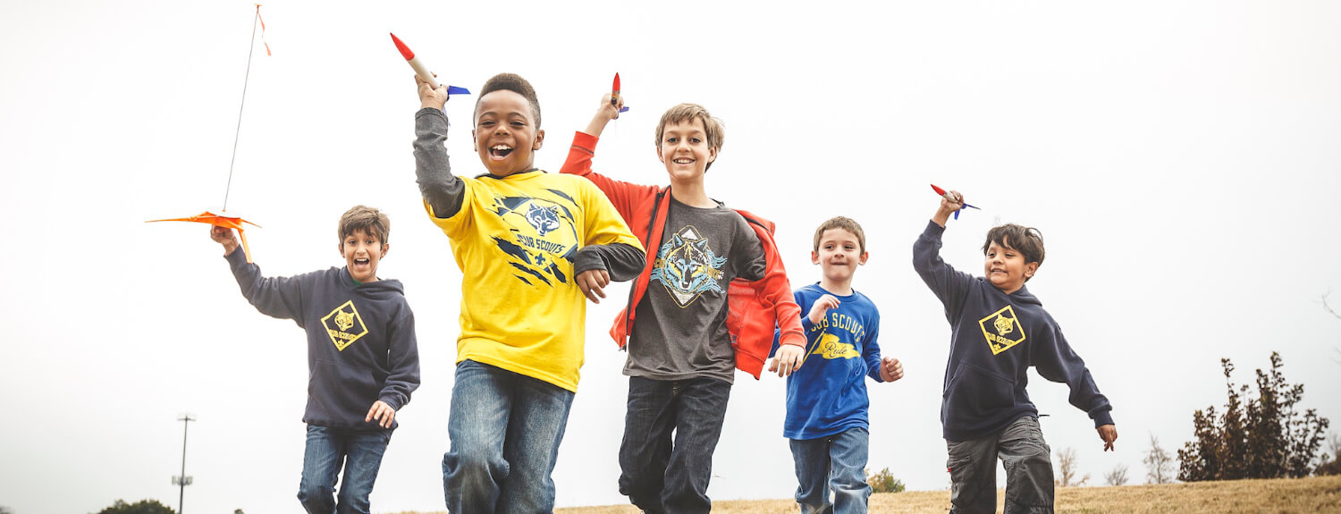 Cub Scouts running with rockets